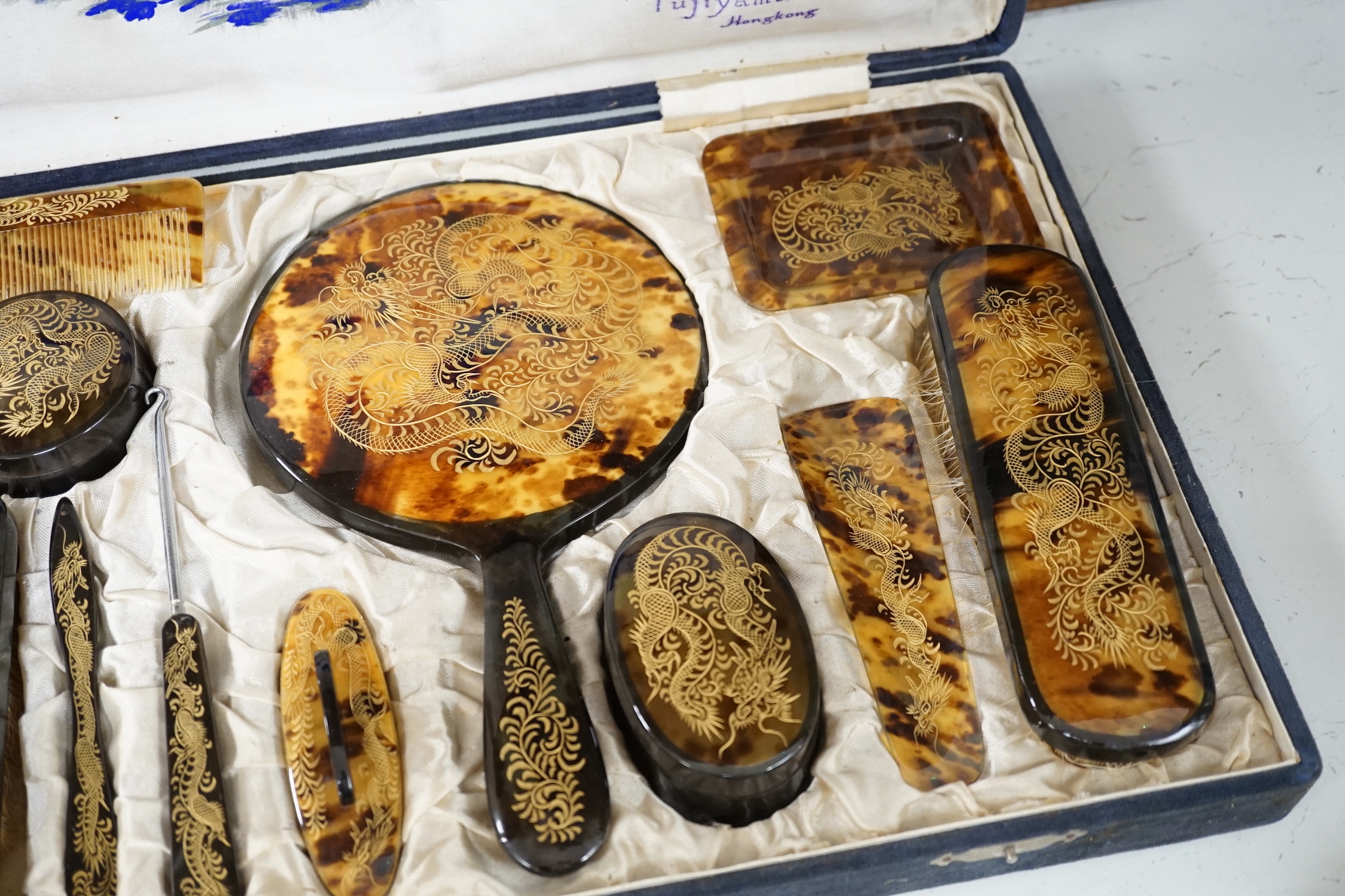 A cased Japanese tortoiseshell dragon decorated dressing table set, c.1940 (with original packing case sent from Hong Kong in 1940)